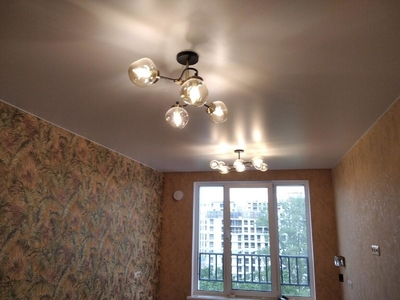Сатиновый натяжной потолок с красивыми люстрами и скрытым карнизом с подсветкой 