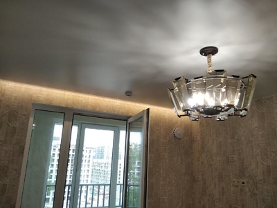 Сатиновый натяжной потолок с красивыми люстрами и скрытым карнизом с подсветкой 