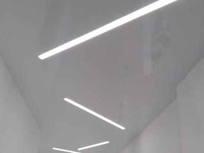 Белый-глянцевый натяжной потолок со световыми линиями в коридоре 