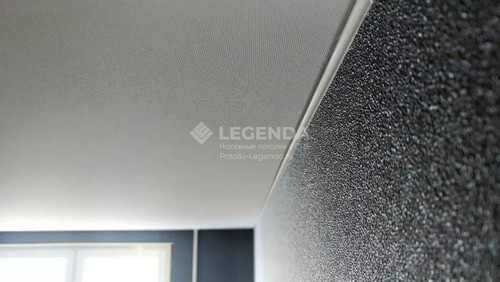 Тканевое полотно  сфотографировано вблизи, видна текстура потолка